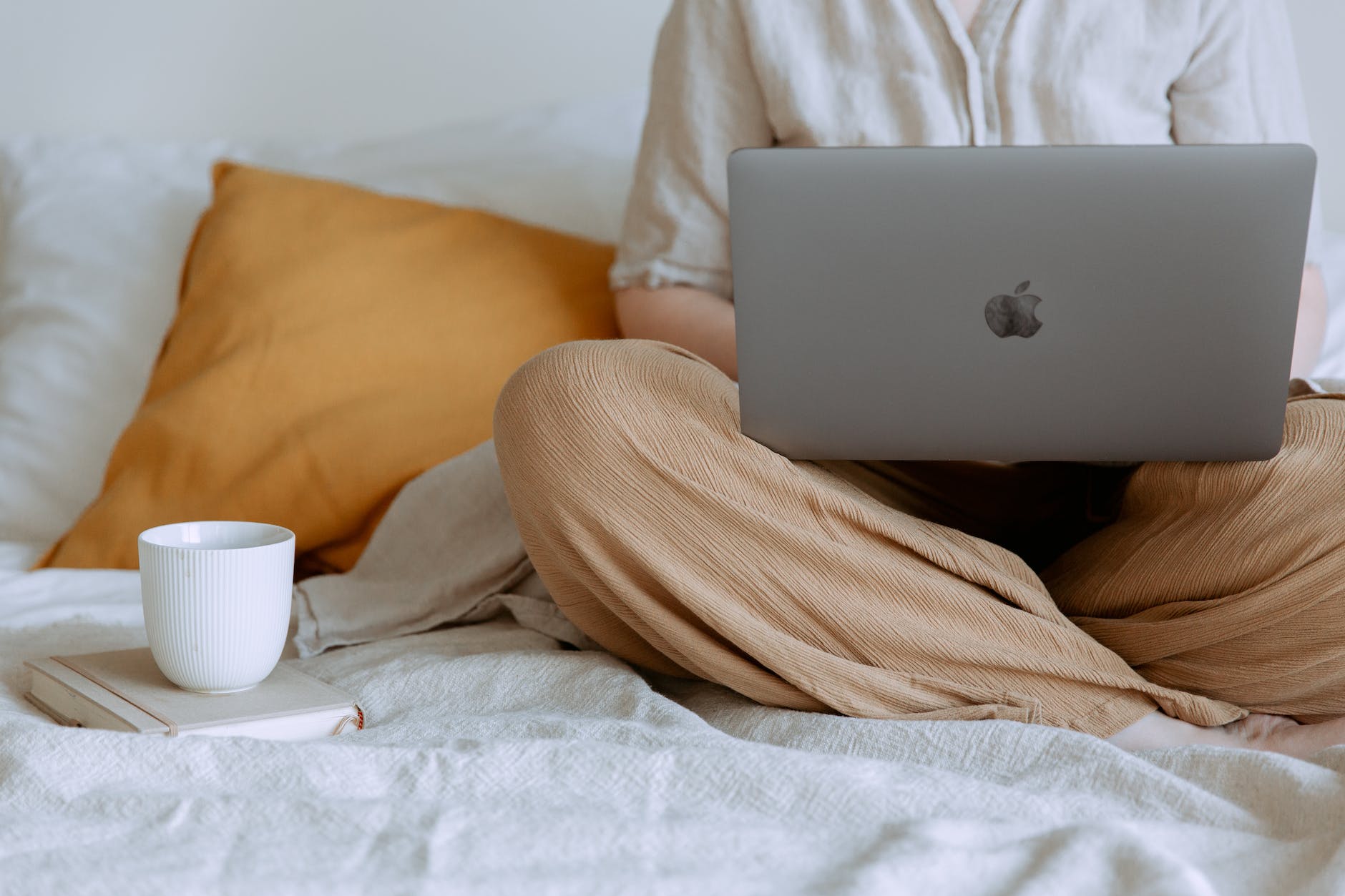 woman using laptop with a cup of coffee.